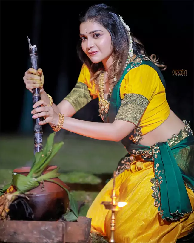 In the photos, Dharsha Gupta Half Saree yellow Pavadai Thavani half-saree, which she paired with a heavy work green dupatta
